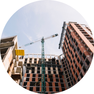 Przemysłowa budowa. Dźwig budowlany przenosi materiały na wyższe kondygnacje powstającego budynku.