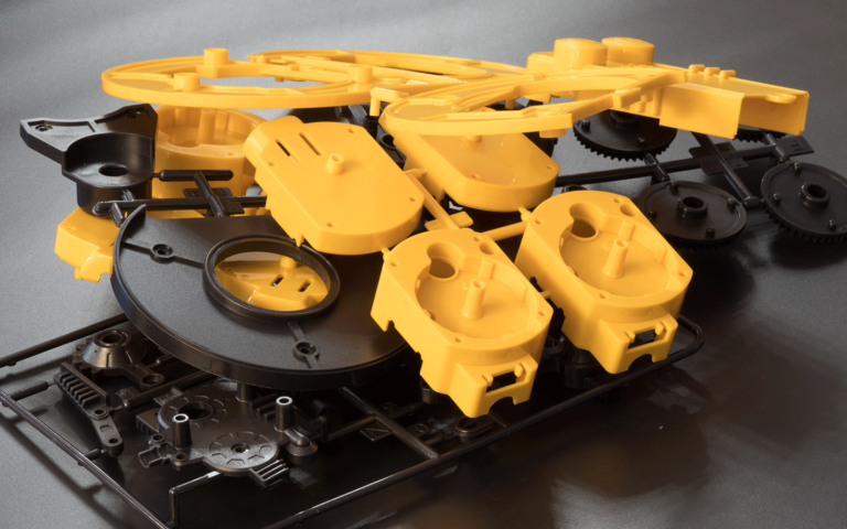 Zestaw formowanych wtryskowo elementów z tworzywa sztucznego, gotowych do montażu w urządzeniu.