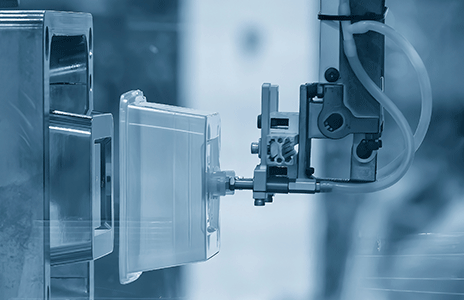 Zautomatyzowany proces produkcyjny. Robot przemysłowy manipuluje plastikową częścią w formie.